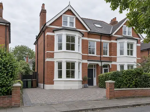 Three-storey Edwardian semi-detached house with bay windows and a block-paved frontage